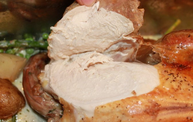 A sliced pastured chicken showing the rich, juicy & flavorful white meat.